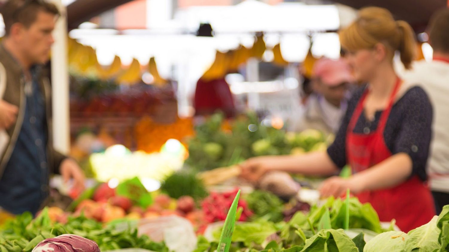 Person serving a customer at a local fruit and vegetable market
