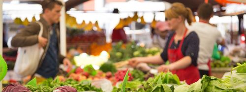 Person serving a customer at a local fruit and vegetable market